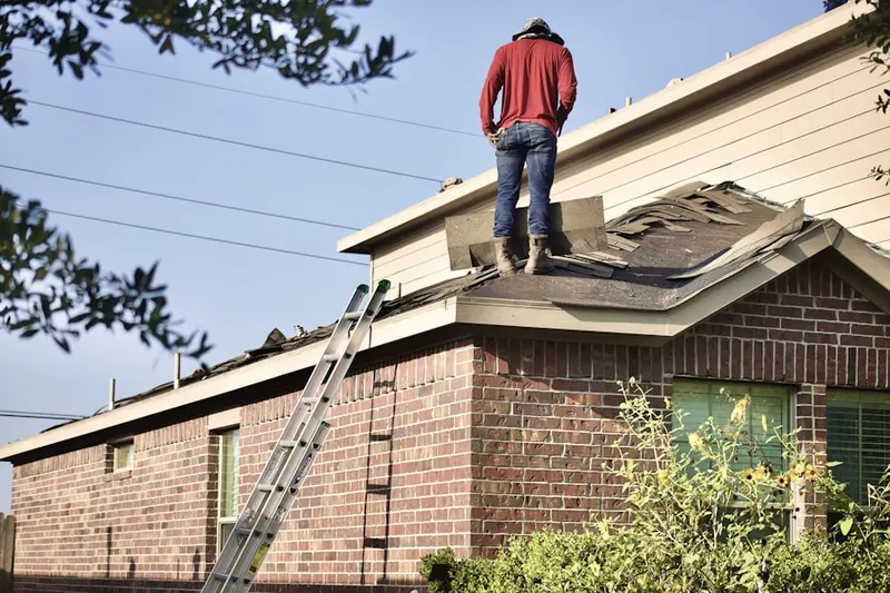 Professional roofer working on a residential roof in Skinners